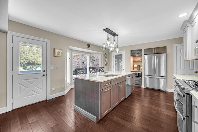 207 Hamilton Ave, Frankfort, IL 60423 - kitchen with stainless steel appliances, light countertops, an island with sink, a chandelier, and dark wood finished floors