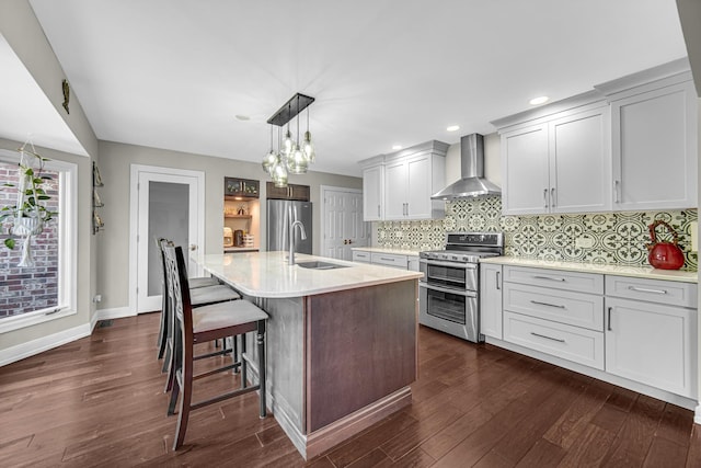 207 Hamilton Ave, Frankfort, IL 60423 - kitchen with wall chimney range hood, appliances with stainless steel finishes, dark wood-style flooring, tasteful backsplash, and pendant lighting