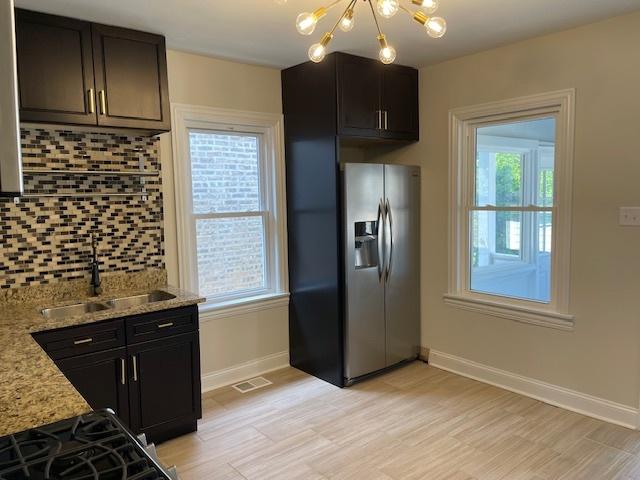 1404 Scoville Ave, Berwyn, IL 60402 - kitchen with tasteful backsplash, a chandelier, light wood-type flooring, stainless steel fridge, and light stone countertops
