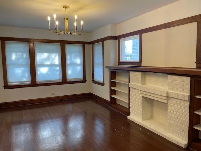 1404 Scoville Ave, Berwyn, IL 60402 - unfurnished living room featuring a chandelier and dark wood-style flooring