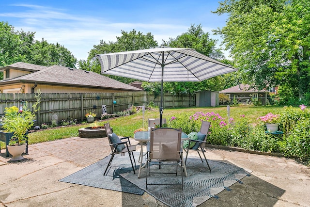 911 N 9th St, Dekalb, IL 60115 - fenced backyard featuring a fire pit, a patio, outdoor dining space, and a storage shed