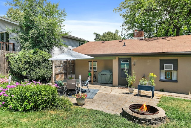911 N 9th St, Dekalb, IL 60115 - back of house featuring a patio, stucco siding, an outdoor fire pit, a chimney, and roof with shingles