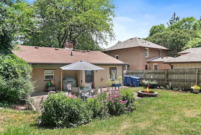 911 N 9th St, Dekalb, IL 60115 - rear view of house with an outdoor fire pit, stucco siding, and a patio