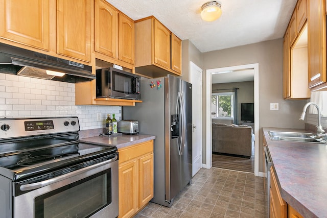 911 N 9th St, Dekalb, IL 60115 - kitchen featuring appliances with stainless steel finishes, under cabinet range hood, and decorative backsplash