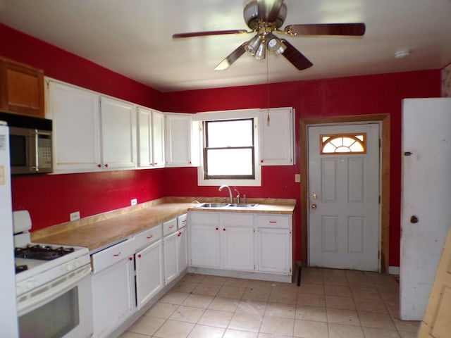 12934 Mozart St, Blue Island, IL 60406 - kitchen with white gas stove, stainless steel microwave, white cabinetry, ceiling fan, and light countertops