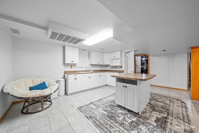92 Neil Rd, Sugar Grove, IL 60554 - kitchen with light tile patterned floors, white cabinets, butcher block countertops, and a center island