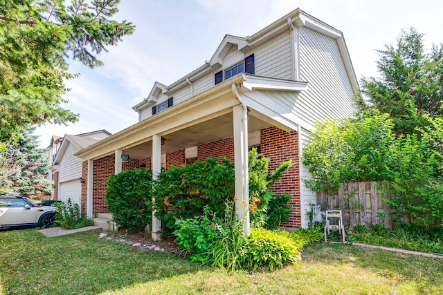 1021 Autumn Dr, Antioch, IL 60002 - view of property exterior with brick siding, a garage, and covered porch