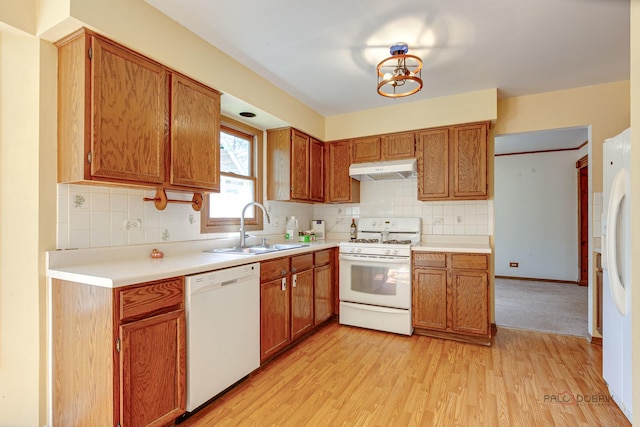 1021 Autumn Dr, Antioch, IL 60002 - kitchen with white appliances, under cabinet range hood, light wood finished floors, and brown cabinetry