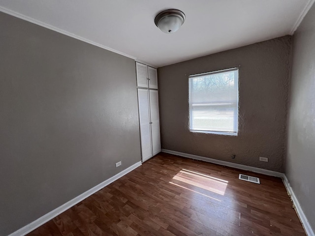 252 Mantua St, Park Forest, IL 60466 - unfurnished bedroom featuring dark wood-style floors, crown molding, and a closet