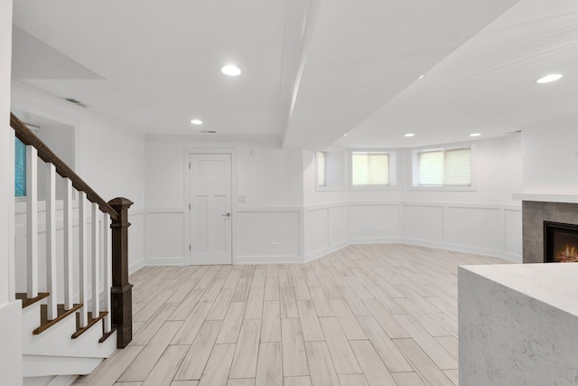 5312 S Woodlawn Ave Unit 1, Chicago, IL 60615 - below grade area featuring stairway, light wood finished floors, a tile fireplace, a decorative wall, and recessed lighting