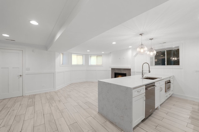 5312 S Woodlawn Ave Unit 1, Chicago, IL 60615 - kitchen with stainless steel appliances, a warm lit fireplace, wood finish floors, open floor plan, and white cabinetry