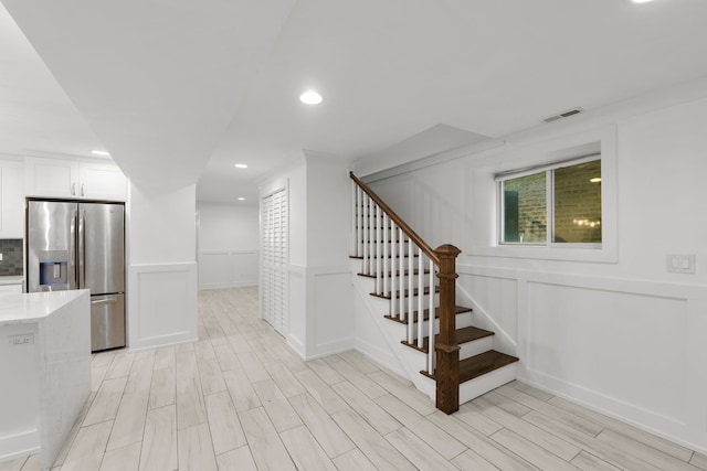 5312 S Woodlawn Ave Unit 1, Chicago, IL 60615 - below grade area with stainless steel fridge, a decorative wall, stairway, light wood-style flooring, and recessed lighting