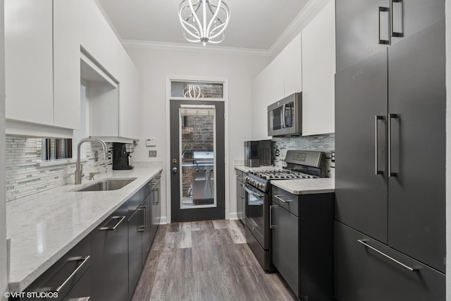 2848 N Burling St Unit 1, Chicago, IL 60657 - kitchen featuring appliances with stainless steel finishes, light stone countertops, white cabinets, dark wood-type flooring, and decorative backsplash