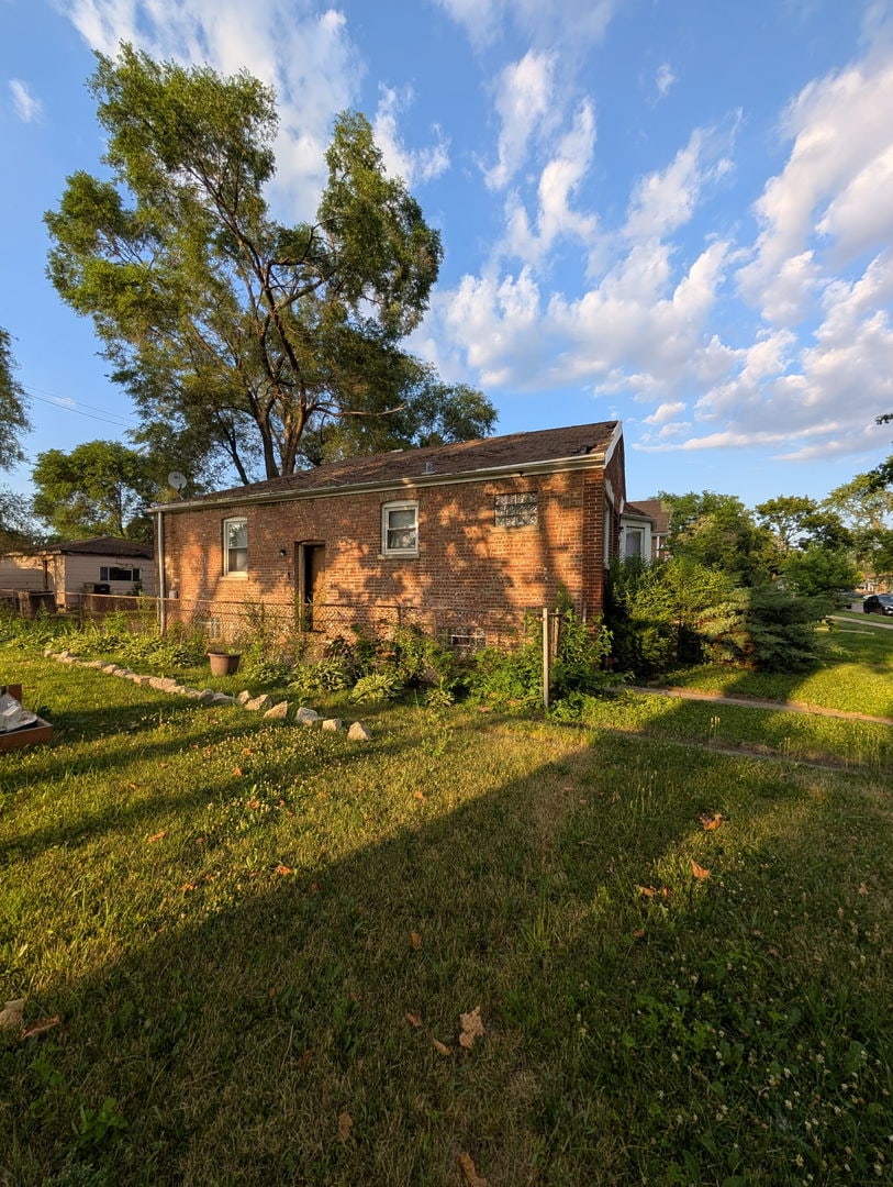 520 W 129th Pl, Chicago, IL 60628 - view of side of home with a lawn and brick siding