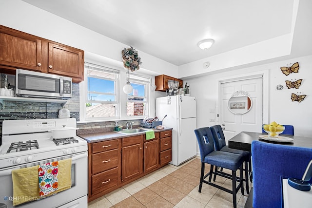 2924 N Mulligan Ave, Chicago, IL 60634 - kitchen featuring white appliances, decorative backsplash, light tile patterned floors, brown cabinets, and dark countertops