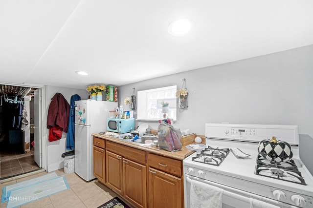 2924 N Mulligan Ave, Chicago, IL 60634 - kitchen featuring white appliances, light tile patterned floors, light countertops, and brown cabinets