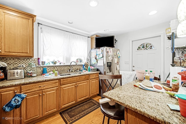 2924 N Mulligan Ave, Chicago, IL 60634 - kitchen with light wood finished floors, a kitchen breakfast bar, decorative backsplash, recessed lighting, and light stone countertops