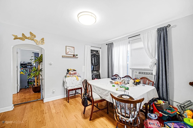 2924 N Mulligan Ave, Chicago, IL 60634 - dining room featuring stacked washer and clothes dryer, light wood finished floors, arched walkways, and cooling unit