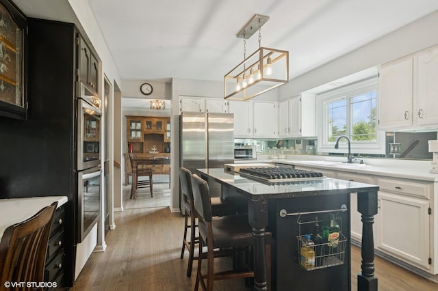 904 Warwick Ln, Lake Zurich, IL 60047 - kitchen with stainless steel appliances, a kitchen island, white cabinetry, and a breakfast bar