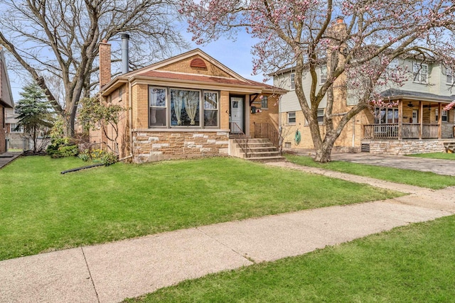 10026 S Spaulding Ave, Evergreen Park, IL 60805 - view of front facade featuring stone siding, a chimney, a front yard, and a porch