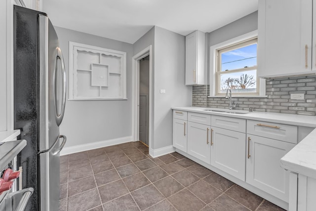 10026 S Spaulding Ave, Evergreen Park, IL 60805 - kitchen with freestanding refrigerator, decorative backsplash, white cabinetry, and light stone counters
