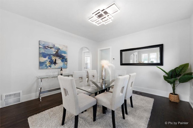 4846 W Roscoe St, Chicago, IL 60641 - dining room featuring arched walkways, wood finished floors, and plenty of natural light