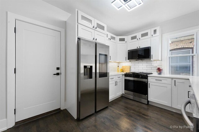 4846 W Roscoe St, Chicago, IL 60641 - kitchen featuring stainless steel appliances, light countertops, dark wood-style floors, white cabinets, and backsplash