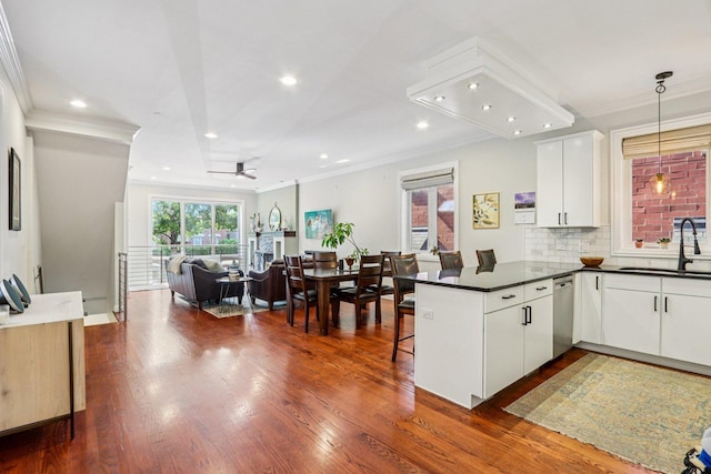 1431 N Artesian Ave Unit 1, Chicago, IL 60622 - kitchen with a peninsula, stainless steel dishwasher, dark countertops, ornamental molding, and dark wood-type flooring