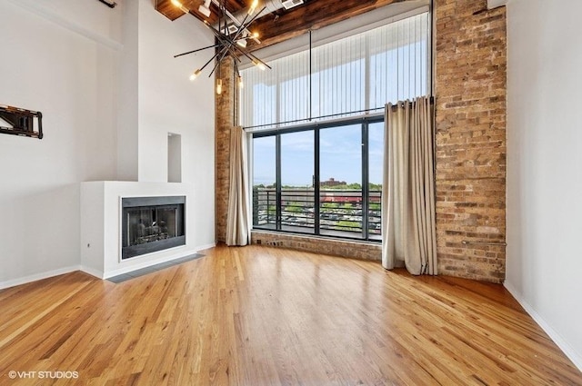 2614 N Clybourn Ave Unit 311, Chicago, IL 60614 - unfurnished living room featuring a high ceiling, a chandelier, wood finished floors, and a multi sided fireplace