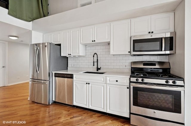 2614 N Clybourn Ave Unit 311, Chicago, IL 60614 - kitchen featuring stainless steel appliances, light countertops, white cabinetry, and light wood finished floors