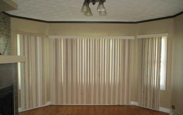 7319 S Claremont Ave, Chicago, IL 60636 - unfurnished living room with wood finished floors, crown molding, and a fireplace