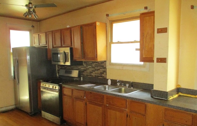 7319 S Claremont Ave, Chicago, IL 60636 - kitchen with appliances with stainless steel finishes, brown cabinetry, dark countertops, tasteful backsplash, and ceiling fan