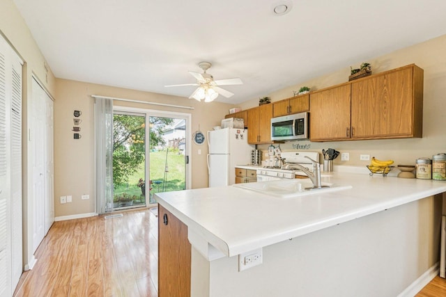 1192 Sumac Trl, Hoffman Estates, IL 60192 - kitchen with light countertops, a peninsula, stainless steel microwave, light wood finished floors, and range