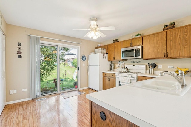 1192 Sumac Trl, Hoffman Estates, IL 60192 - kitchen featuring white appliances, light countertops, light wood-type flooring, brown cabinetry, and ceiling fan