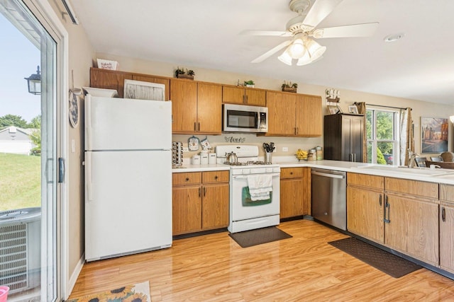 1192 Sumac Trl, Hoffman Estates, IL 60192 - kitchen with stainless steel appliances, light countertops, light wood-style floors, ceiling fan, and brown cabinetry