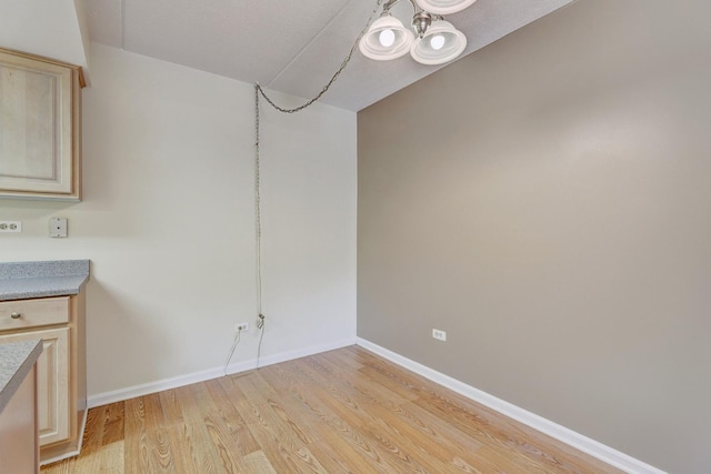 512 Redondo Dr Unit 112, Downers Grove, IL 60516 - unfurnished dining area featuring light wood-style flooring and a chandelier