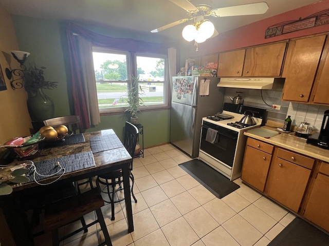 201 S Roy Ave, Northlake, IL 60164 - kitchen featuring white gas range oven, under cabinet range hood, a ceiling fan, brown cabinetry, and freestanding refrigerator