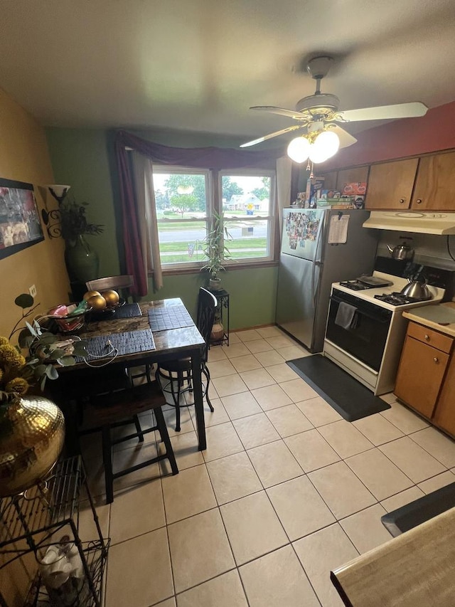 201 S Roy Ave, Northlake, IL 60164 - kitchen with white range with gas stovetop, under cabinet range hood, light tile patterned floors, a ceiling fan, and freestanding refrigerator
