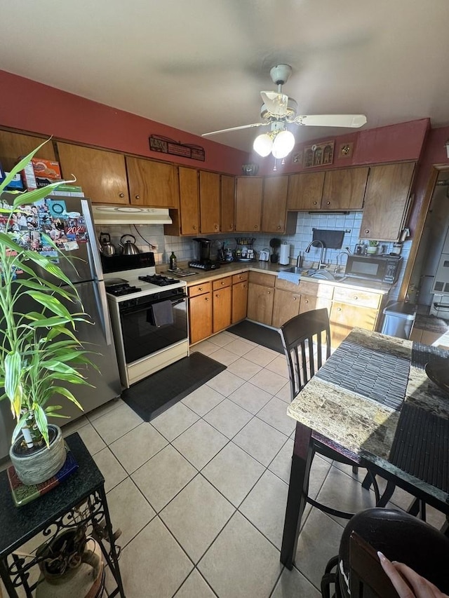 201 S Roy Ave, Northlake, IL 60164 - kitchen featuring white gas stove, under cabinet range hood, freestanding refrigerator, light countertops, and light tile patterned floors