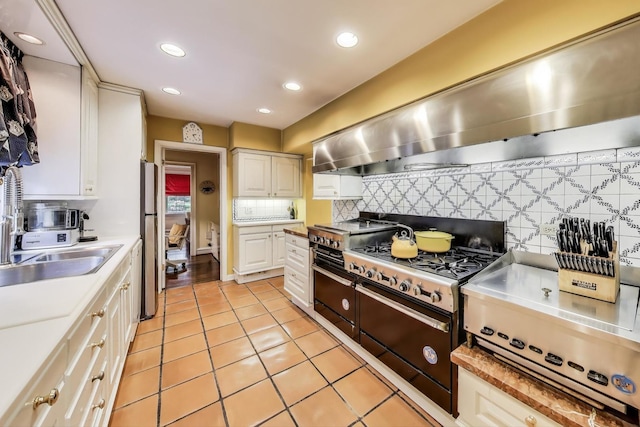 1667 Sunnyside Ave, Highland Park, IL 60035 - kitchen with stainless steel appliances, light tile patterned floors, tasteful backsplash, wall chimney exhaust hood, and light countertops