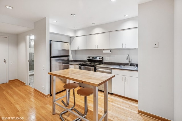 40 E 9th St Unit 903, Chicago, IL 60605 - kitchen featuring stainless steel appliances, dark countertops, light wood finished floors, white cabinetry, and recessed lighting