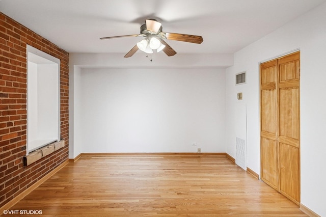40 E 9th St Unit 903, Chicago, IL 60605 - empty room with brick wall, light wood-style floors, and ceiling fan