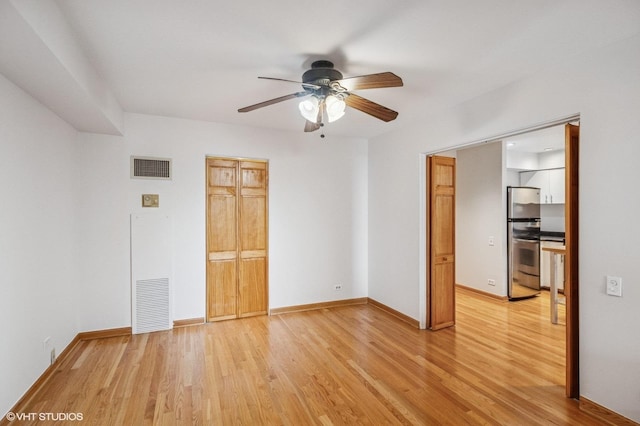 40 E 9th St Unit 903, Chicago, IL 60605 - unfurnished bedroom featuring freestanding refrigerator, light wood-type flooring, and a ceiling fan