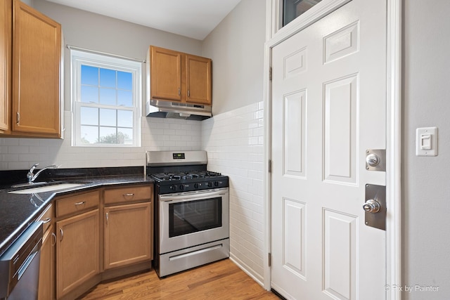 4321 N Drake Ave Unit 3W, Chicago, IL 60618 - kitchen featuring stainless steel appliances, under cabinet range hood, dark countertops, light wood-type flooring, and backsplash
