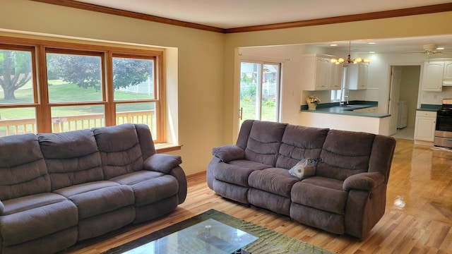 630 Maple Ct, Elburn, IL 60119 - living room featuring healthy amount of natural light, light wood-style floors, crown molding, a chandelier, and washer / dryer