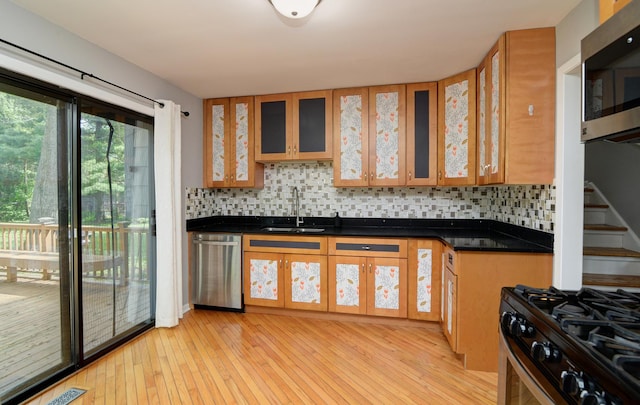 29W324 Grove Ave, West Chicago, IL 60185 - kitchen with appliances with stainless steel finishes, decorative backsplash, light wood-style floors, dark countertops, and glass insert cabinets