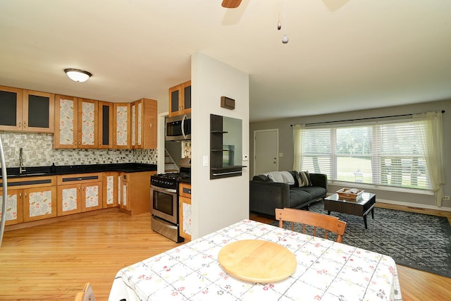 29W324 Grove Ave, West Chicago, IL 60185 - kitchen with stainless steel appliances, light wood-style floors, backsplash, glass insert cabinets, and ceiling fan