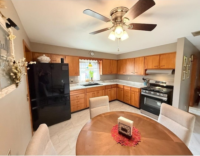 1217 S 7th Ave, Kankakee, IL 60901 - kitchen with stainless steel range with gas stovetop, freestanding refrigerator, under cabinet range hood, light countertops, and ceiling fan