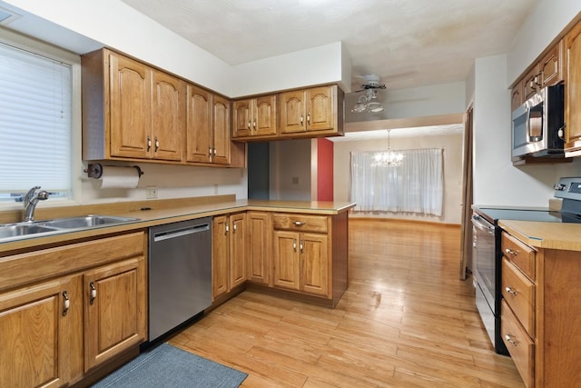 1405 1st Ave, Sterling, IL 61081 - kitchen with stainless steel appliances, a peninsula, a chandelier, and brown cabinets