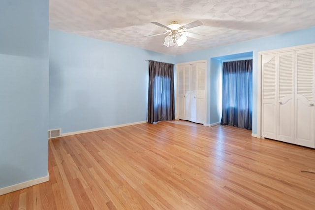 1405 1st Ave, Sterling, IL 61081 - unfurnished bedroom featuring two closets, light wood finished floors, and ceiling fan